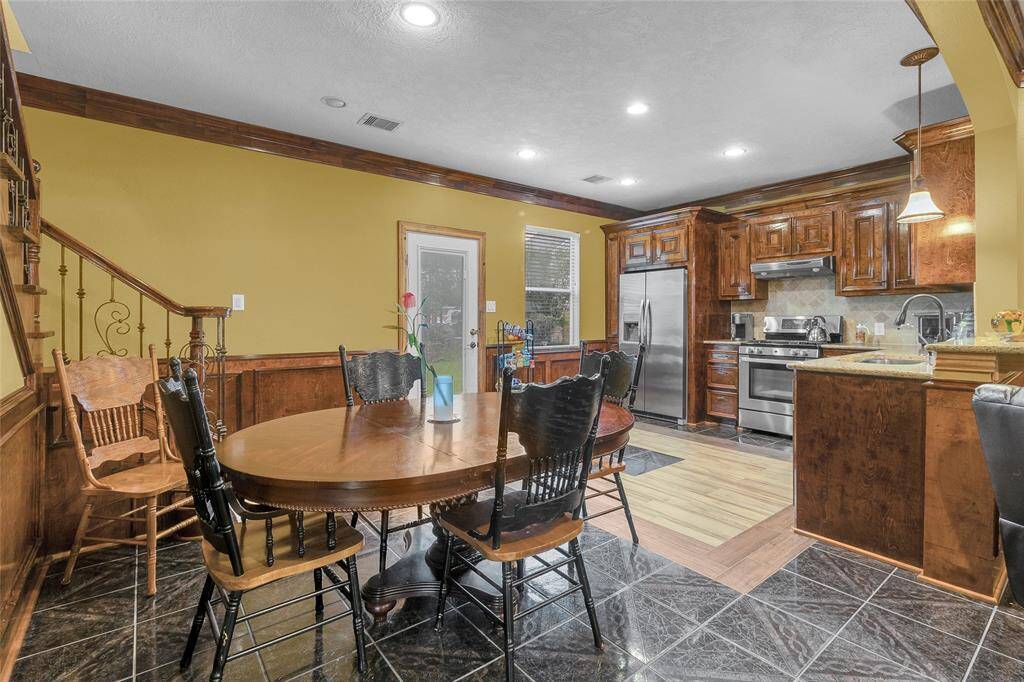 Charming Dining Space: Adjoining a well-appointed kitchen, this inviting dining area with warm wood accents and elegant lighting offers the perfect setting for memorable meals and gatherings.