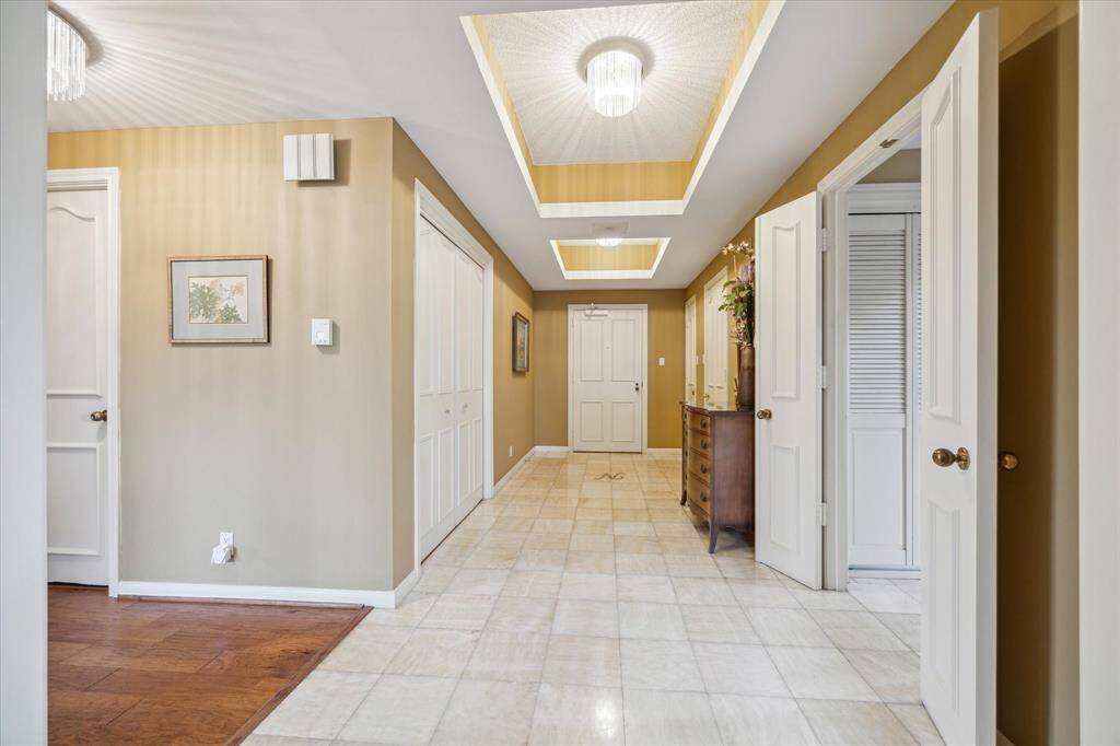 Stylish entryway from the living area, with the kitchen on the right and a hallway on the left leading to guest and primary suites.