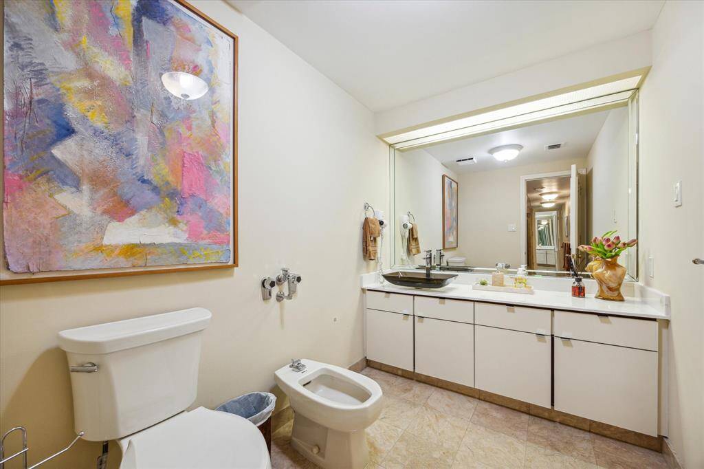 This newly upgraded bathroom features a modern vessel sink and sleek counter space next to the tub and shower.