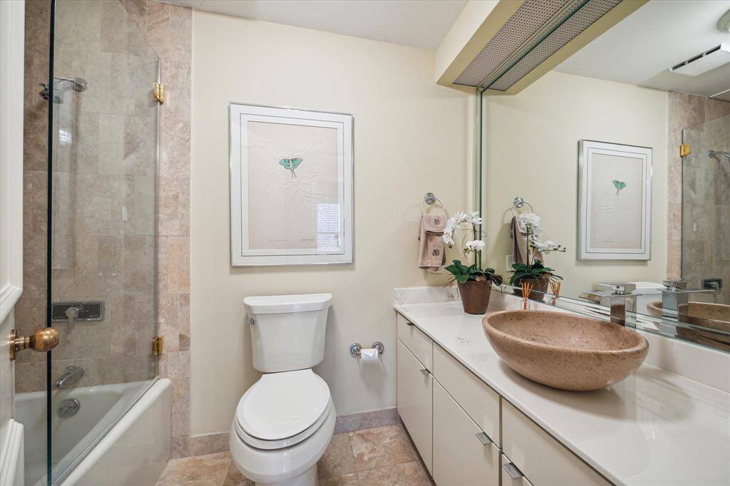 Experience modern comfort in the guest bath, featuring a sleek tub/shower combo, a new countertop, and a stylish vessel sink.