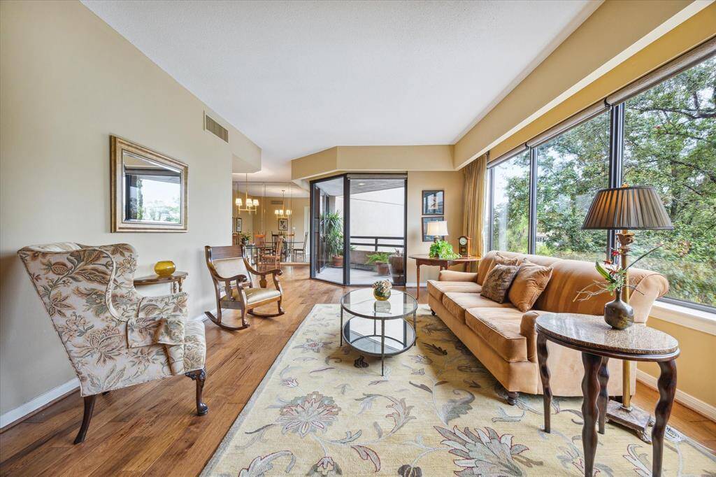 Step into a spacious 14x24 ft living room, perfect for versatile seating and entertaining. Enjoy serene views with tree-lined windows.