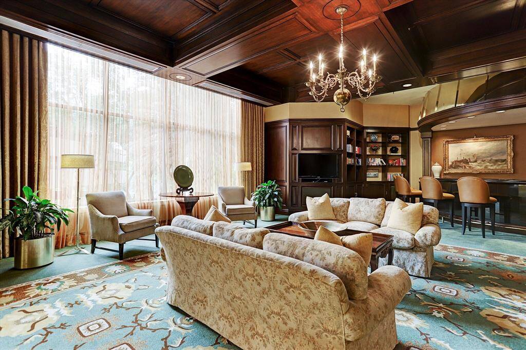 The spacious Azalea Room offers inviting seating areas, a card table, and a well-equipped bar perfect for entertaining.