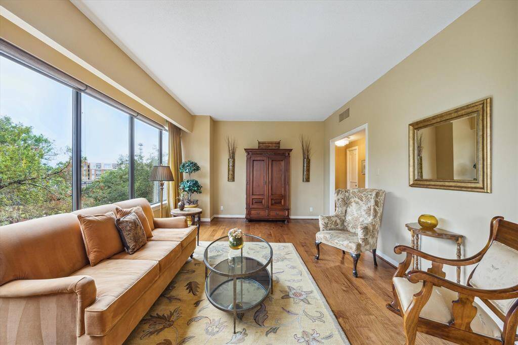 Spacious living room with elegant wood floors and abundant natural light.