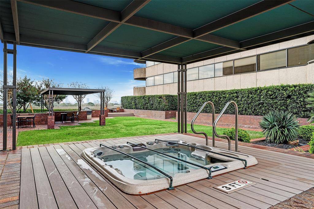 Discover your private urban oasis featuring a luxurious hot tub on a sleek wooden deck, an inviting pergola-shaded lounge area.