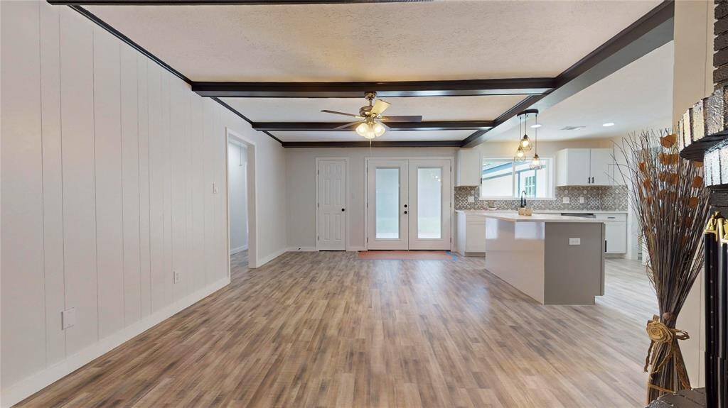Distinct, dark ceiling beams and a neutral color palette, offering a contemporary yet warm atmosphere.
