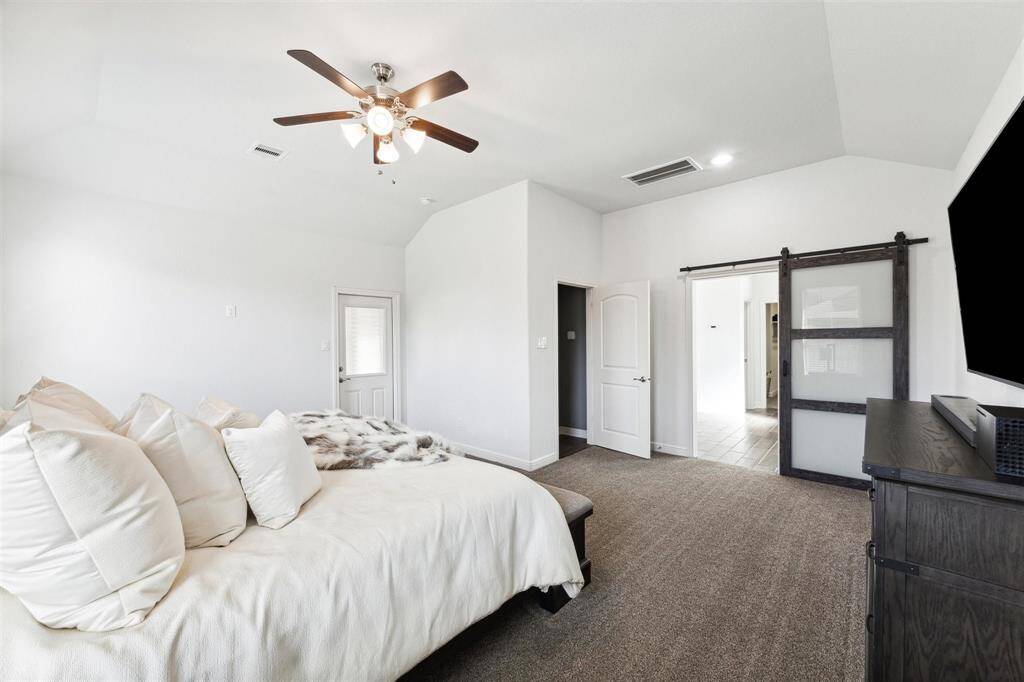 Primary Bedroom Room with Ceiling Fan, 1st Floor with Modern Barn Door to Primary Bathroom.