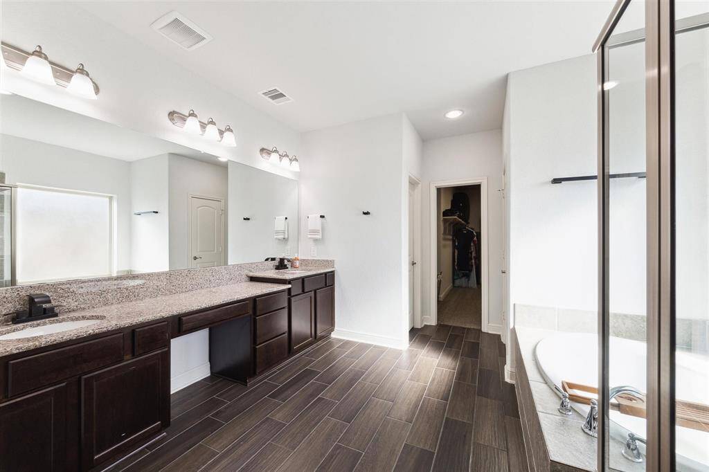 Primary Bathroom offers Large Counter Space with Dual Sinks and built in Vanity Sit-Down Area.