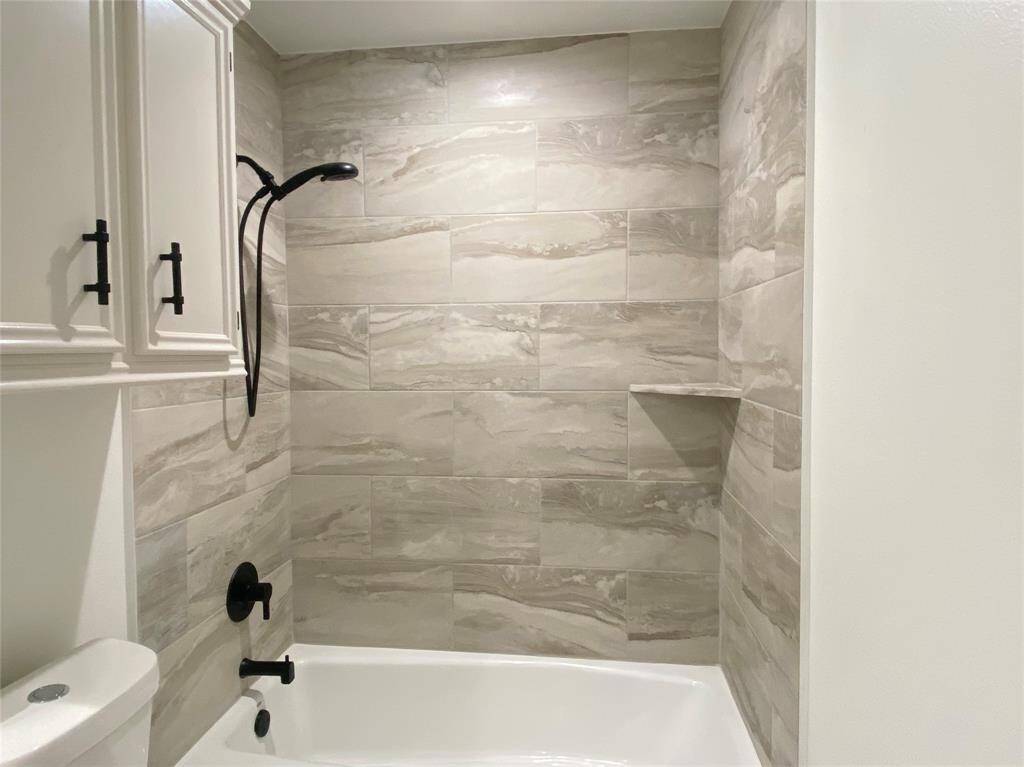 Hall bathroom has tub/shower combo with tile surround
