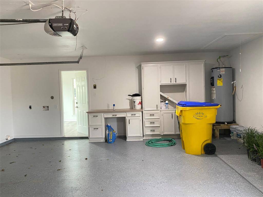 Painted garage floor with built-in cabinetry and washer/dryer hookups