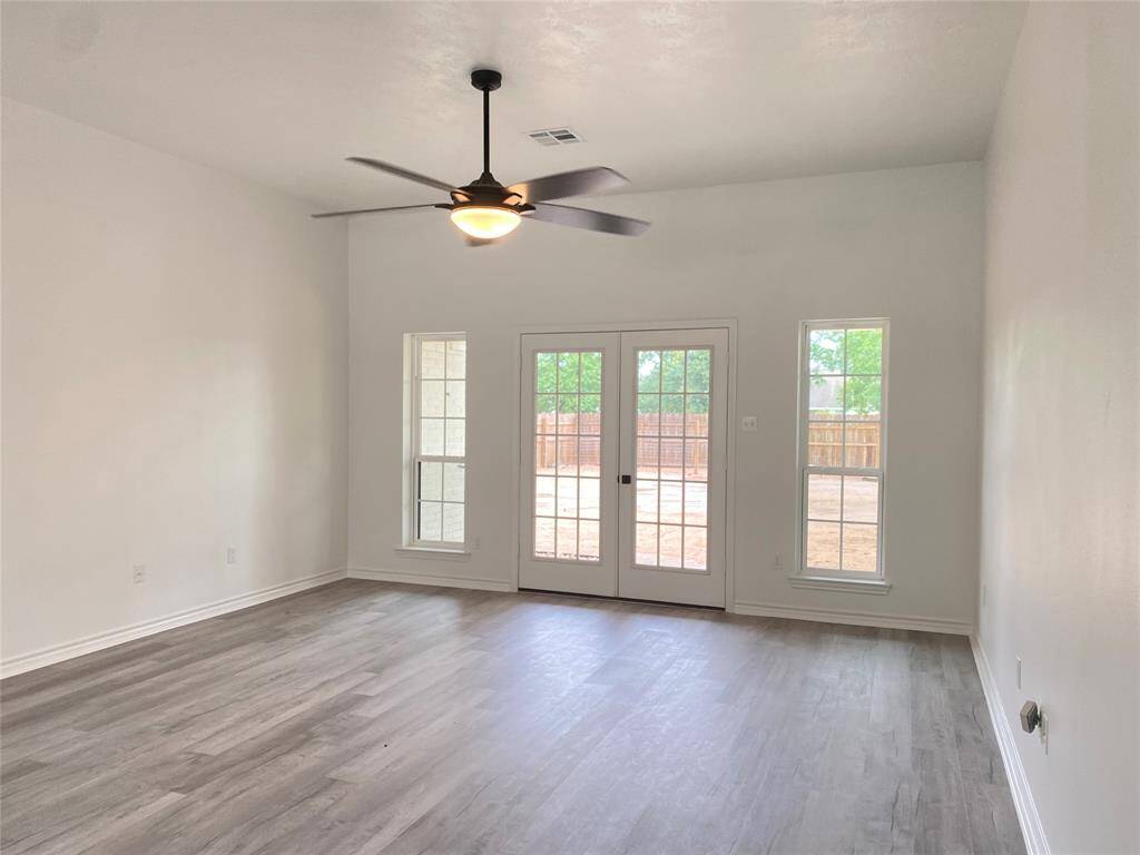 Double French doors lead out to covered back patio and fenced yard