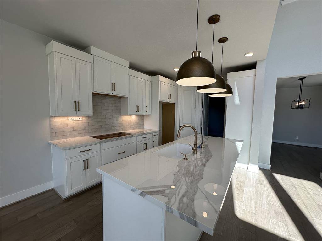Beautiful lighting enhances the open floor plan with light cabinetry and upgraded counters.