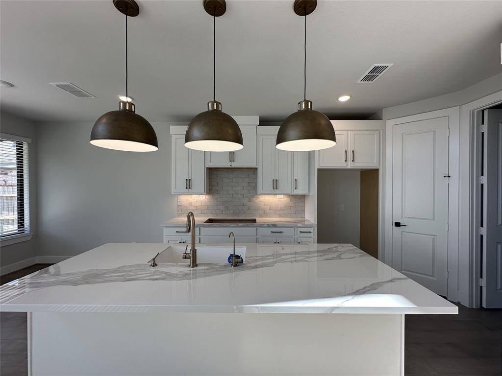 Hardwood floors enhance the first floor and high ceilings in the family room feel so open and spacious.