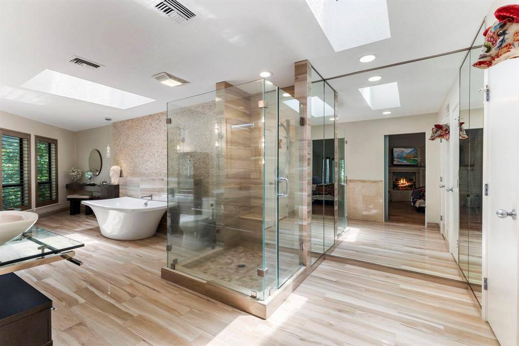 Contemporary touches throughout include the owners spa bath where sky lights offer generous natural light showcasing an eye-catching soaker tub, walk-in shower and his and her vanities.