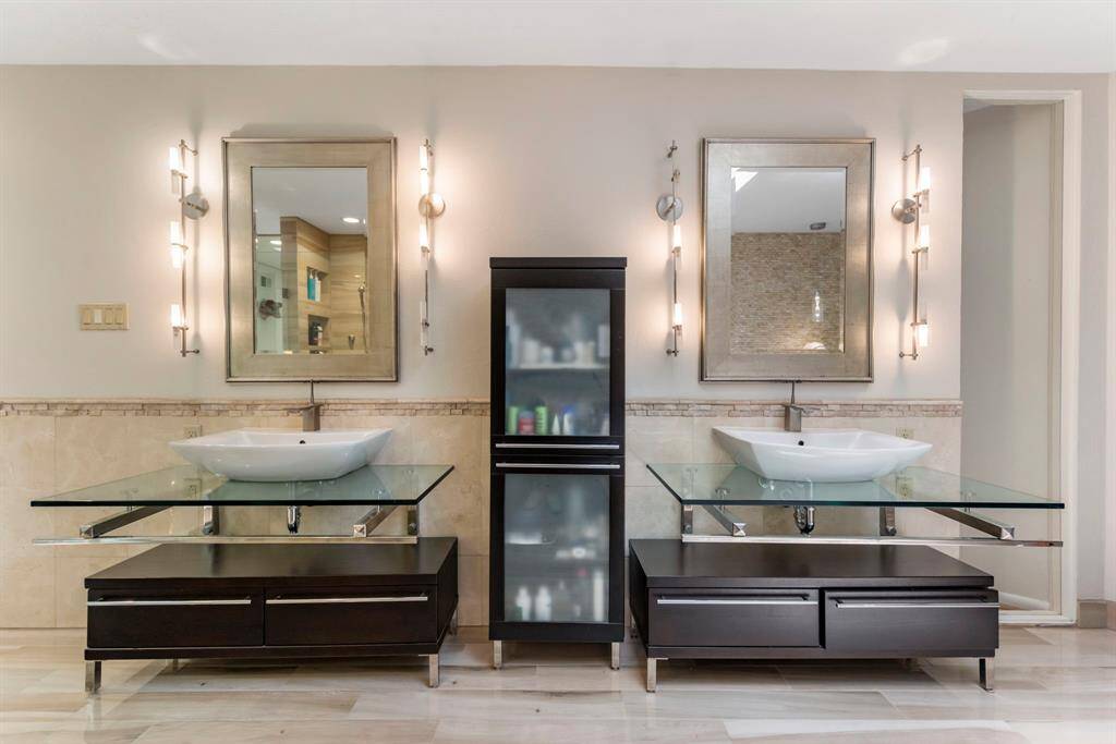 Stunning vessel sinks and drawer systems create the illusion of floating his and her sinks.