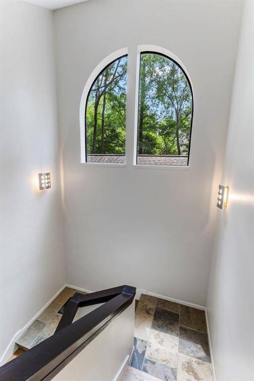 Almost every space in the house presents "picture perfect". Located in the stairway,  trees are framed by an arched window.