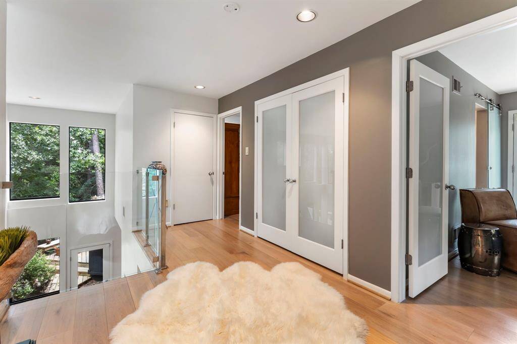 The second level loft features transparent glass railing creating an open and airy feel.
