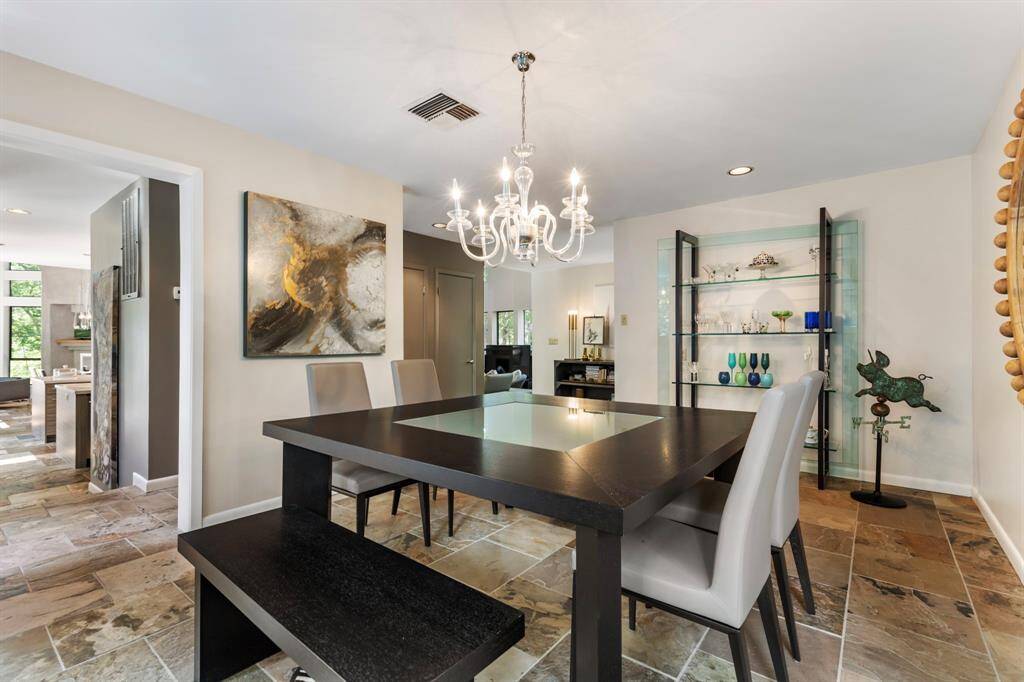 Timeless slate and wood flooring and expansive panes of glass emphasize views of the natural surroundings from almost every room of the house.