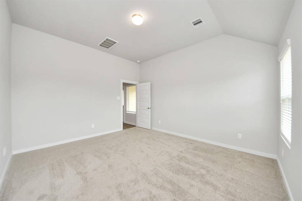 Come and unwind after a long day in this magnificent primary suite! This spacious room features plush carpet, warm paint, high ceilings and large windows with privacy blinds.