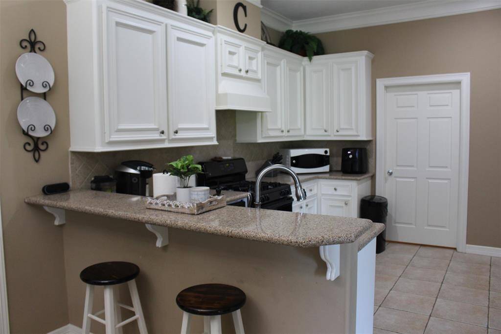 Breakfast bar, creates extra sitting areas to watch the chef prepare memorable meals in this kitchen.