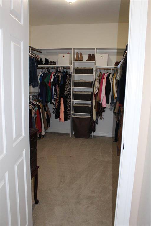 Huge walk in  closet off primary bath with built in shelves.
