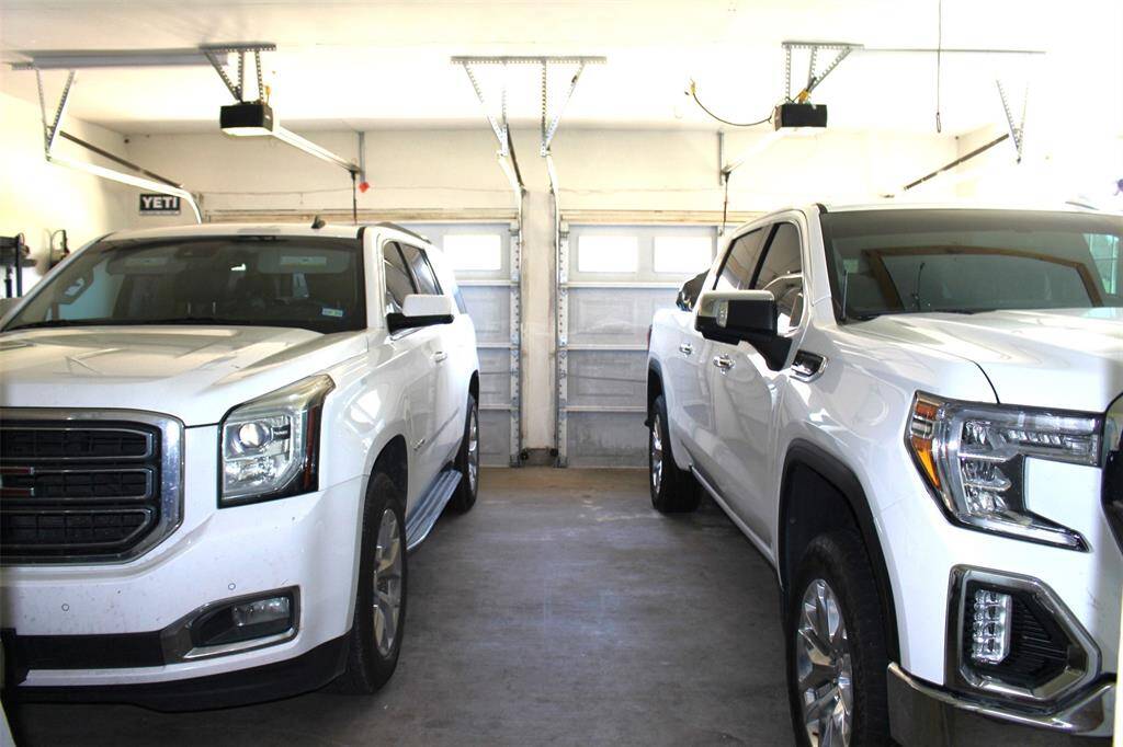 2 Car attached garage. Shown here with two full size vehicles. Also floored attic space for additional storage.