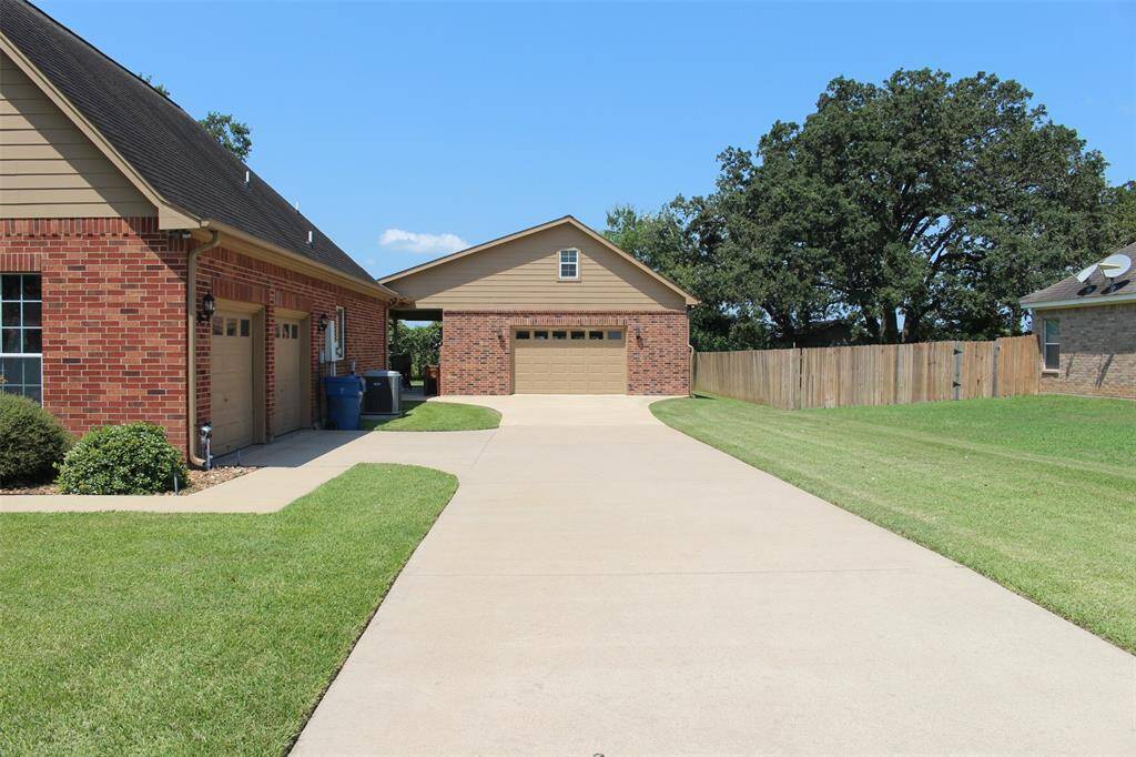 Additional Garage with concrete drive for additional parking. Roll up doors, in front back and left side.