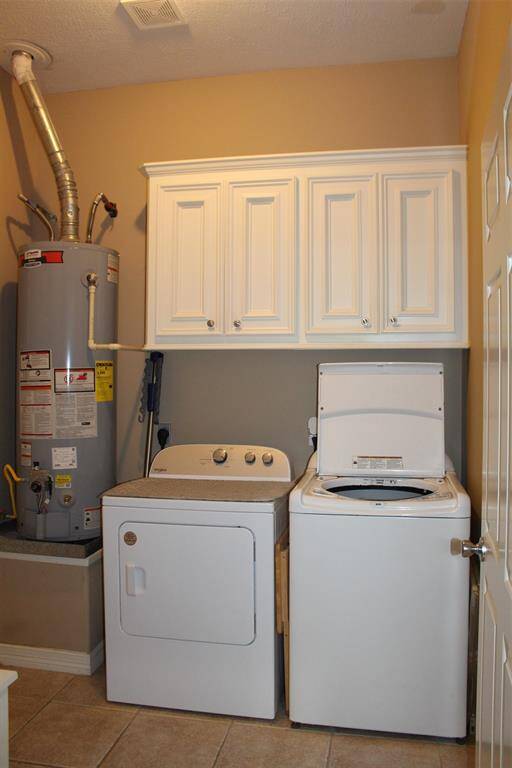 Utility room in house with above cabinets for storage.