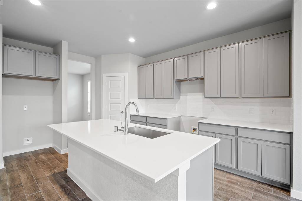 Quietly nestled in front of the home is the handsome home office. Featuring plush carpet flooring, high ceilings, large windows with privacy blinds and custom paint.