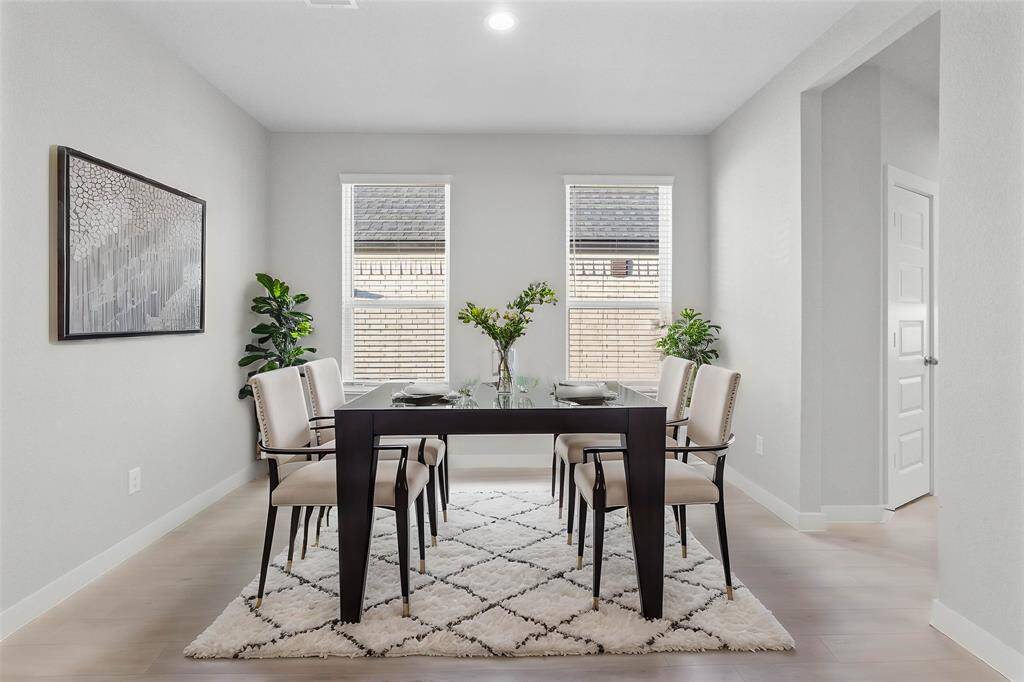 You and your guests will certainly dine in style in this amazing formal dining room! Featuring large windows with blinds, neutral paint, high ceilings, and wood look tile flooring! Perfect space to entertain family and friends!