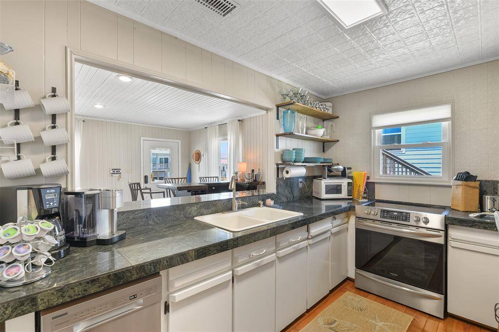 The kitchen opens up to the dining and bar space.
