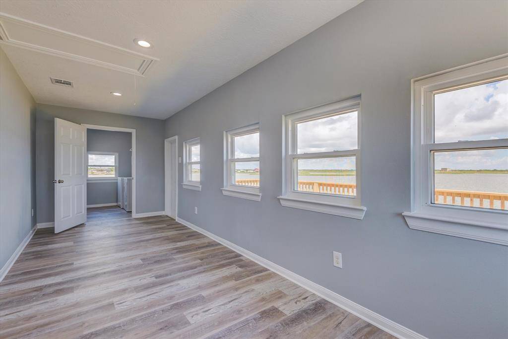 Enclosed porch area with views to the water and utility room at the end.