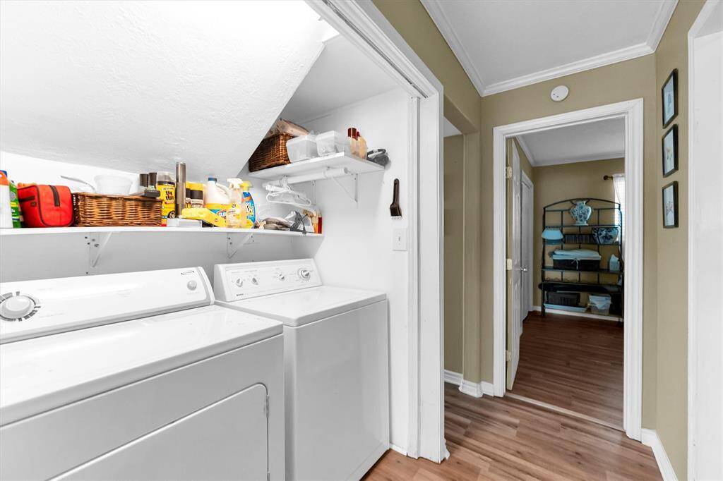 Functional laundry area with overhead storage shelves, and easy access to adjacent rooms.