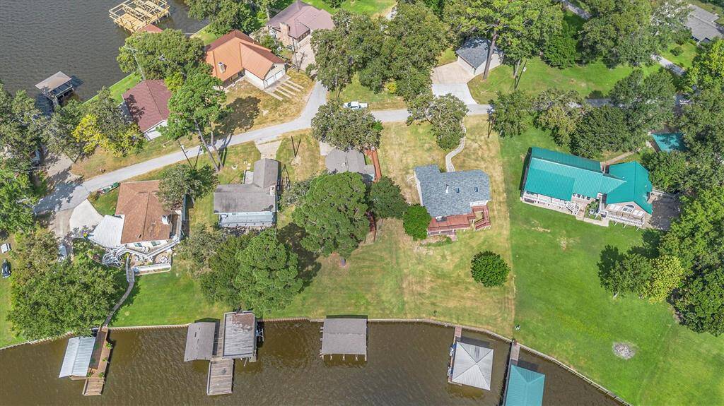 Aerial photo of this lovely a waterfront property with a private boat dock, and neighboring homes in a serene, tree-lined neighborhood.