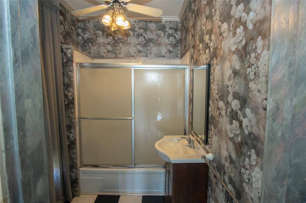 This full bath has been updated with a stylish glass top vanity.