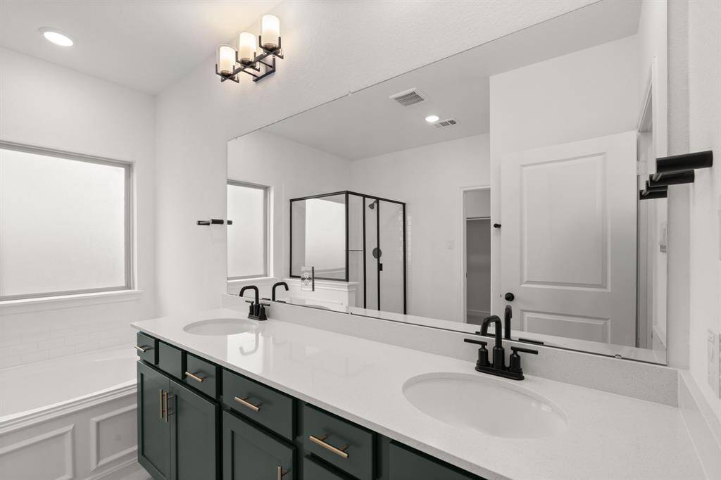 The en-suite bathroom offers a spa-like atmosphere with its elegant design, high end finishes, and tasteful lighting, creating a retreat within your own home.