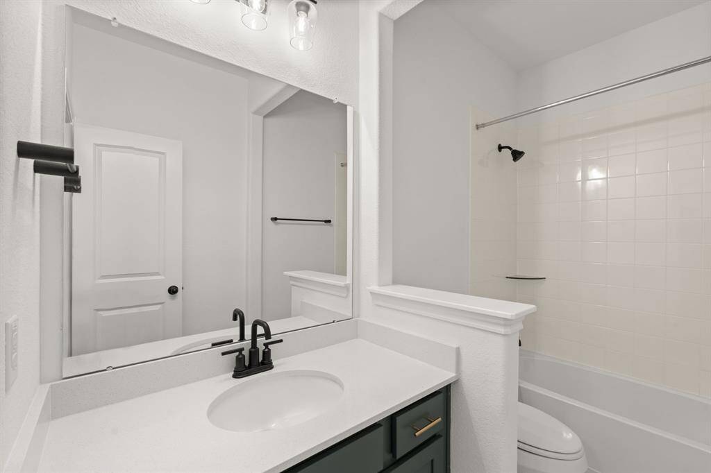 The secondary bath features tile flooring, white cabinetry and light countertops and a shower/tub combo. Perfect for accommodating any visiting family and friends.