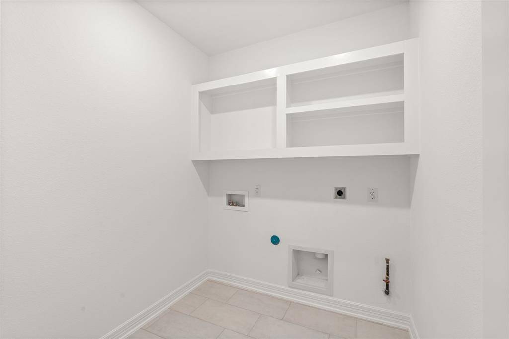 The laundry room layout is carefully planned for optimal workflow with designated areas for washing, drying, and storing.