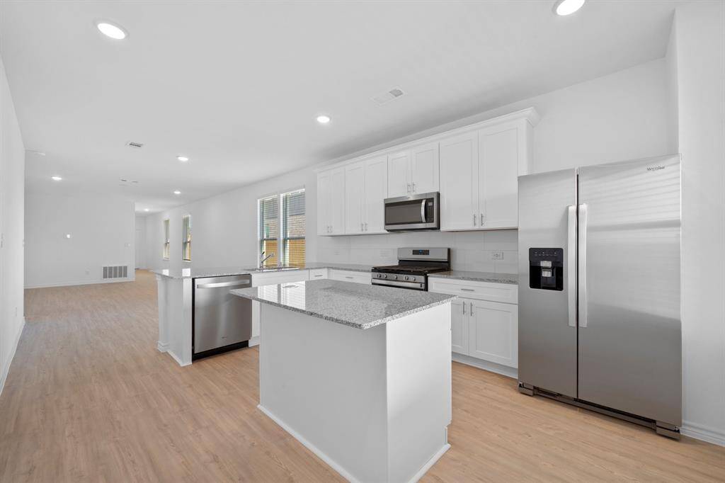 Kitchen featuring Whirpool Stainless Steel appliances, 5 burner Gas stove, and granite countertops