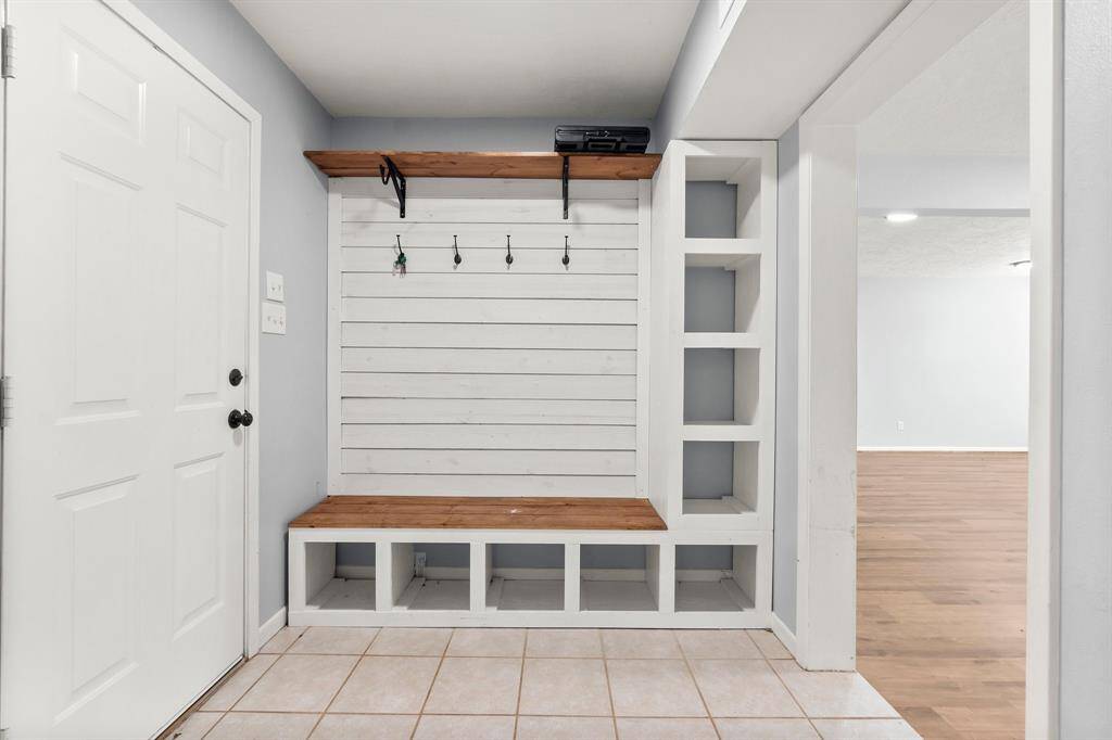 Convenient side entry with a stylish, built-in mudroom bench and storage.