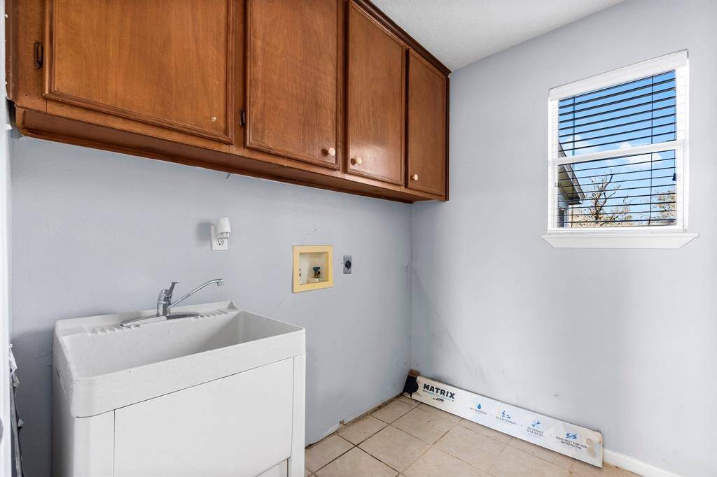 Efficient laundry space with ample cabinetry and natural light.