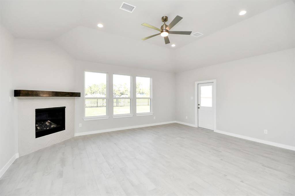 Gather the family and guests together in your lovely living room! Featuring soaring highceilings, recessed lighting, ceiling fan, custom paint, gorgeous floors, and large windows thatprovide plenty of natural lighting throughout the day.