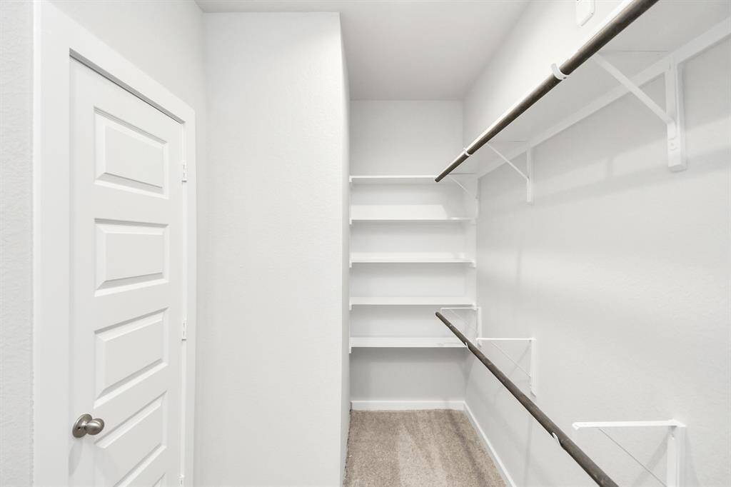 Walk-in closet that epitomizes luxury and practicality. This generously sizedspace features built-in shelving, offering abundant room for impeccableorganization. High ceilings and recessed lighting create a bright andwelcoming ambiance.