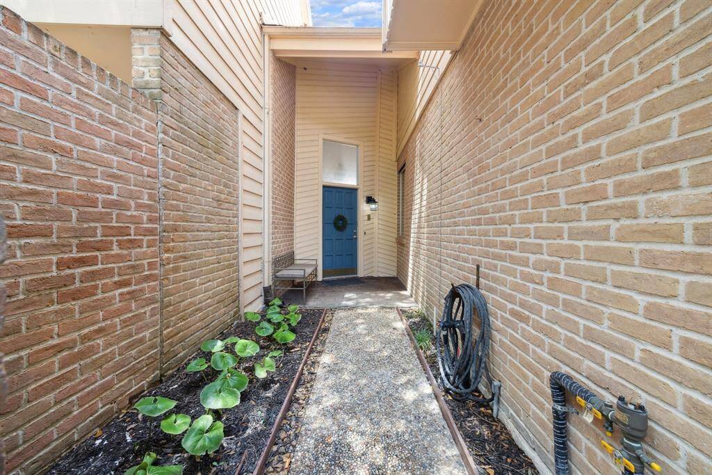 Beyond a gated entry is a private walkway to the home's front door.  Notice the quaint, "secret" garden which welcomes you along the way!