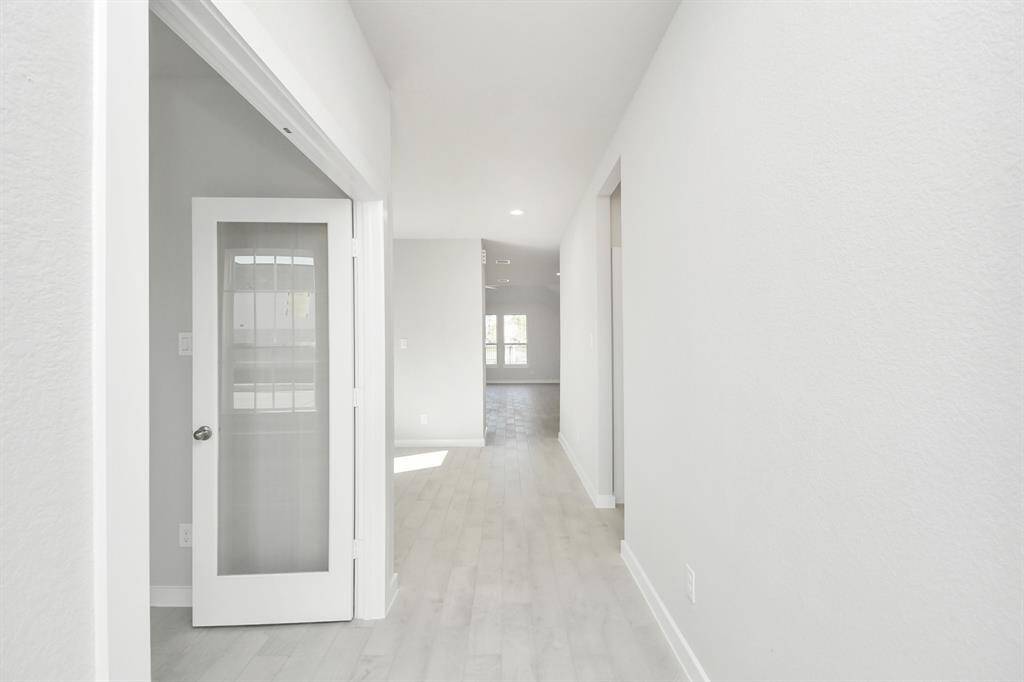 The majestic entryway allures with its high ceilings, embellished with sophisticated wood-look tile flooring and sleek oversized baseboards.