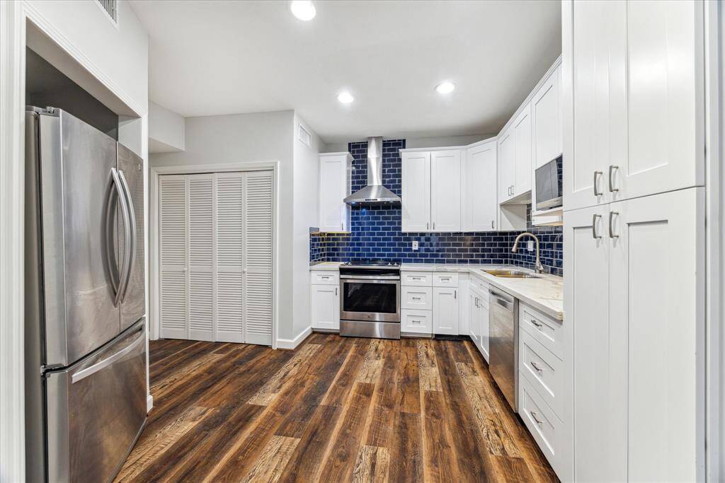 This angle captures the generously sized Kitchen with stainless steel appliances.  Note behind the louvered doors is a full size washer and dryer.