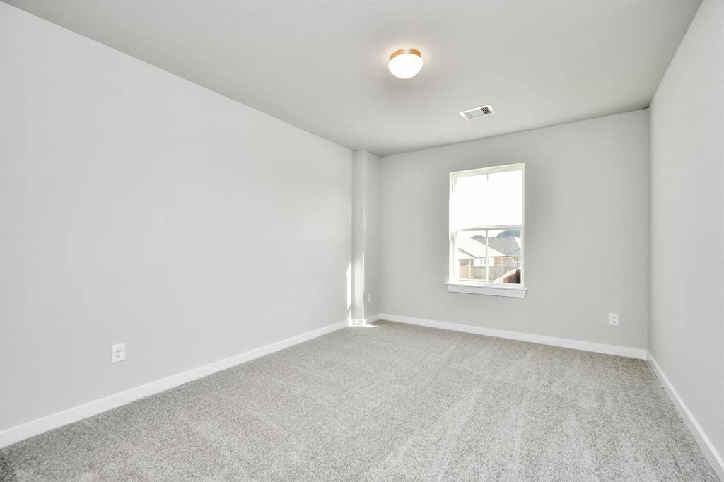 Generously sized secondary bedrooms featuring spacious closets, soft and inviting carpeting underfoot, large windows allowing plenty of natural light, and the added touch of privacy blinds for your personal retreat. Sample photo of completed home with similar floor plan. As-built interior colors and selections may vary.