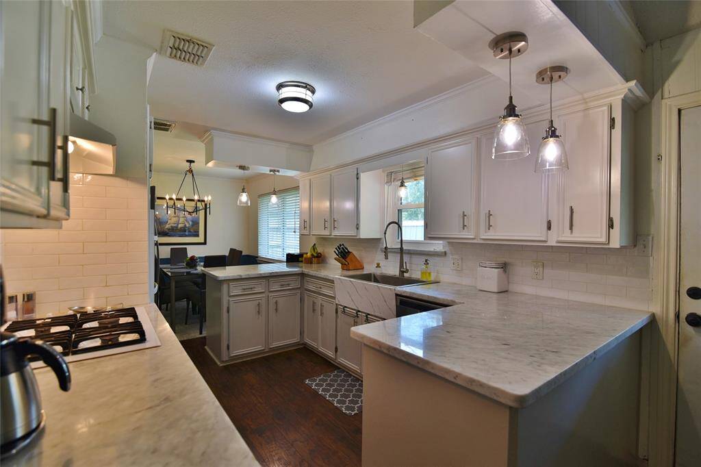 Farmhouse sink with a view to the large outside yard area....matching pendants over each side of the prep areas....