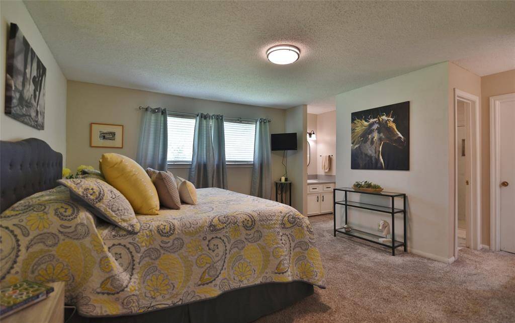 Primary bedroom sits at the rear of the home with a view of the back yard area.....spacious king size bed and still plenty of room inside this bedroom area....Split vanities for two people with two walk-in closets....
