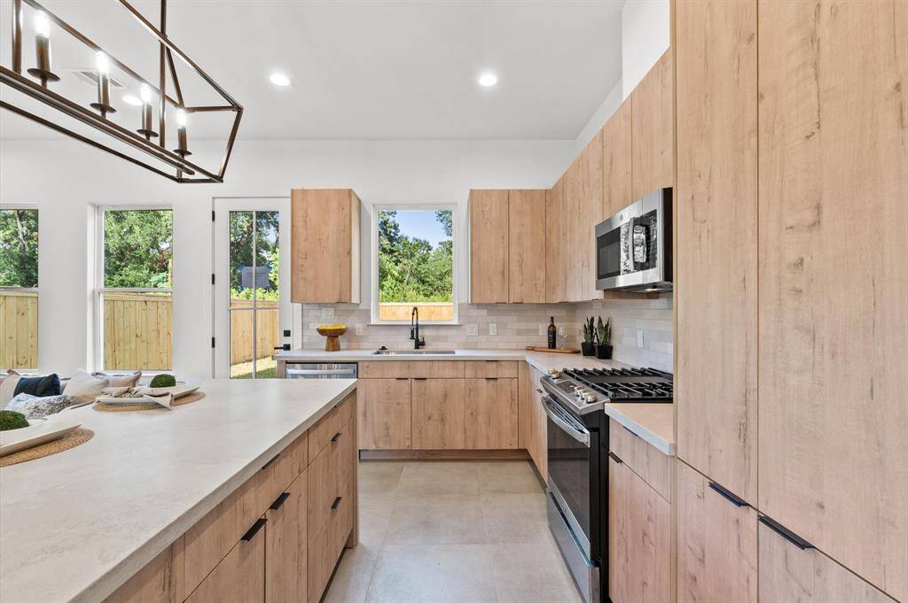 Arcadia Yellow Walnut cabinetry with Artic White with Coral Luster Quartz Countertops.