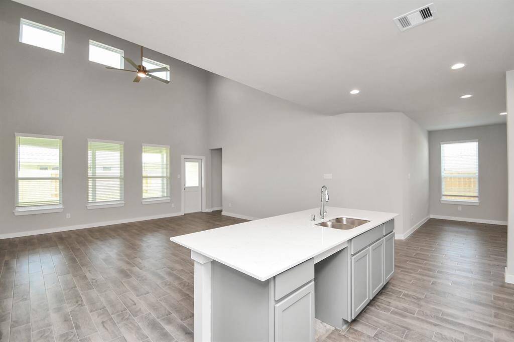 This kitchen is by far any chef’s dream! This spacious kitchen features high ceilings, light stained wood cabinets, granite countertop, SS appliances, modern tile backsplash, recessed lighting, extended counter space, granite kitchen island with double sink, and space for breakfast bar, and a walk-in pantry all overlooking your huge family room.